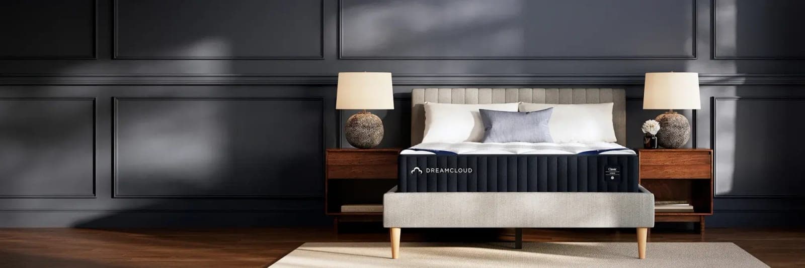 A DreamCloud hybrid mattress in a dark-panelled bedroom