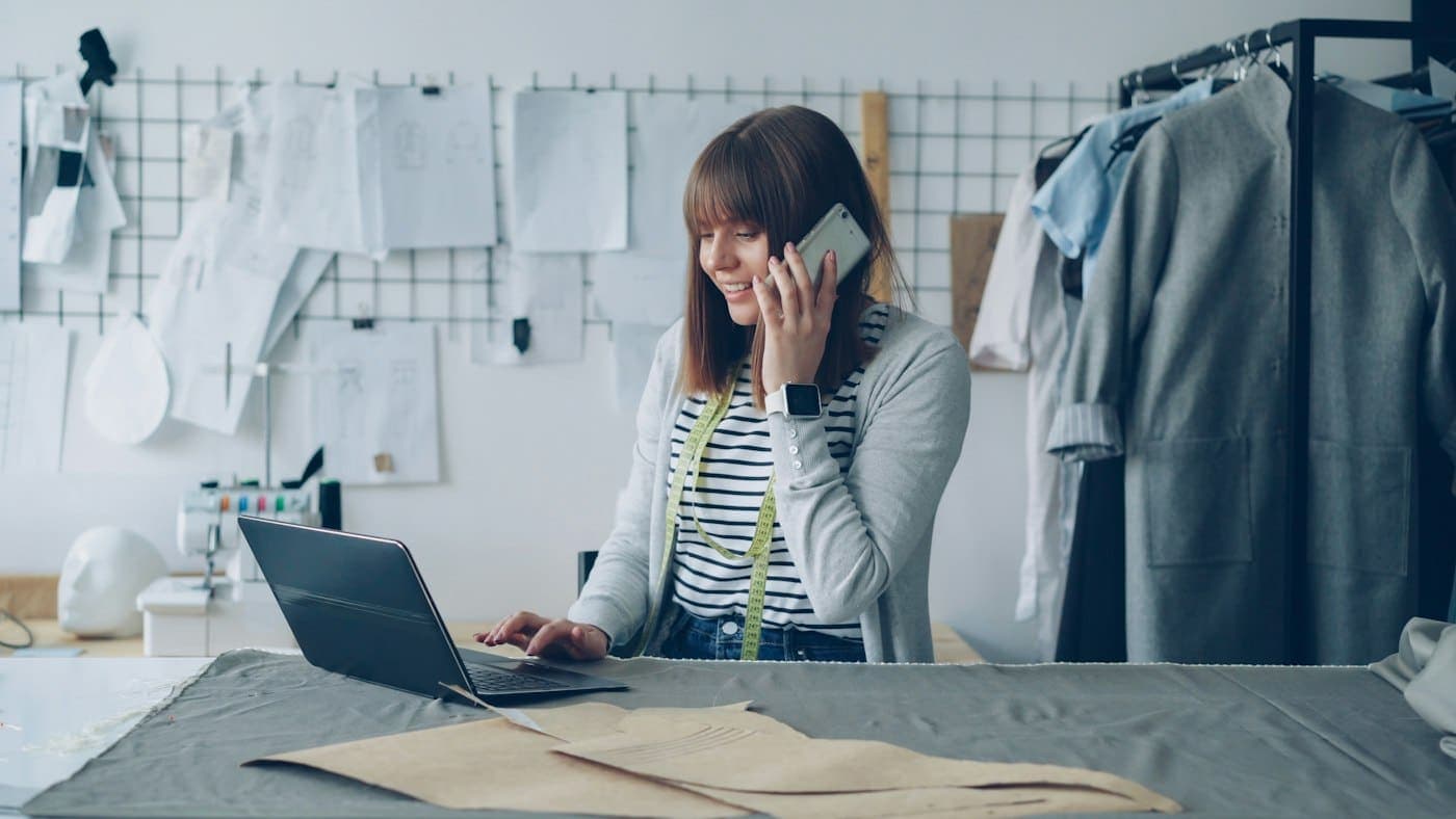 A fashion founder taking a call at her laptop