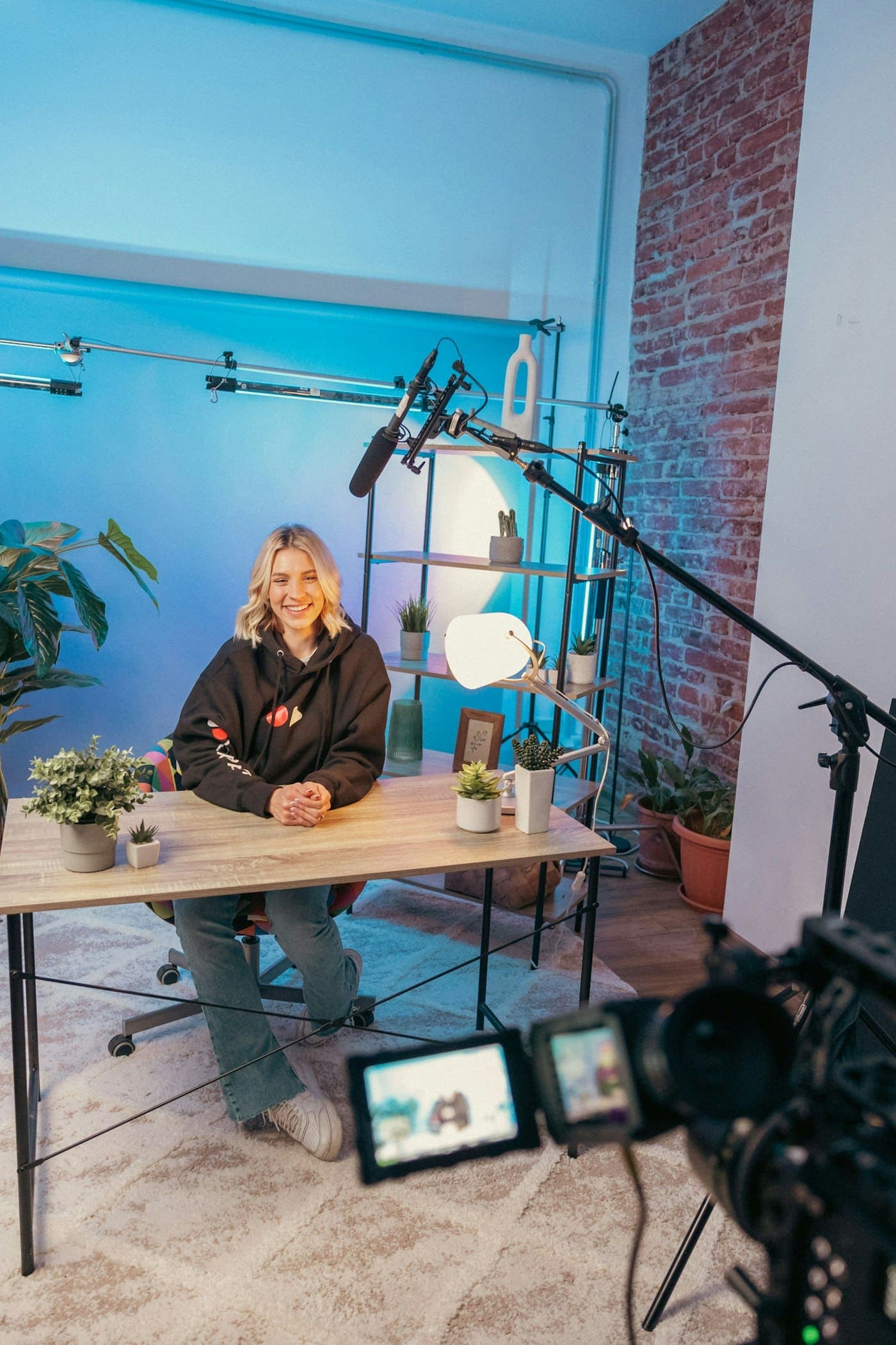 A creator filming at her desk with lights and a camera set up