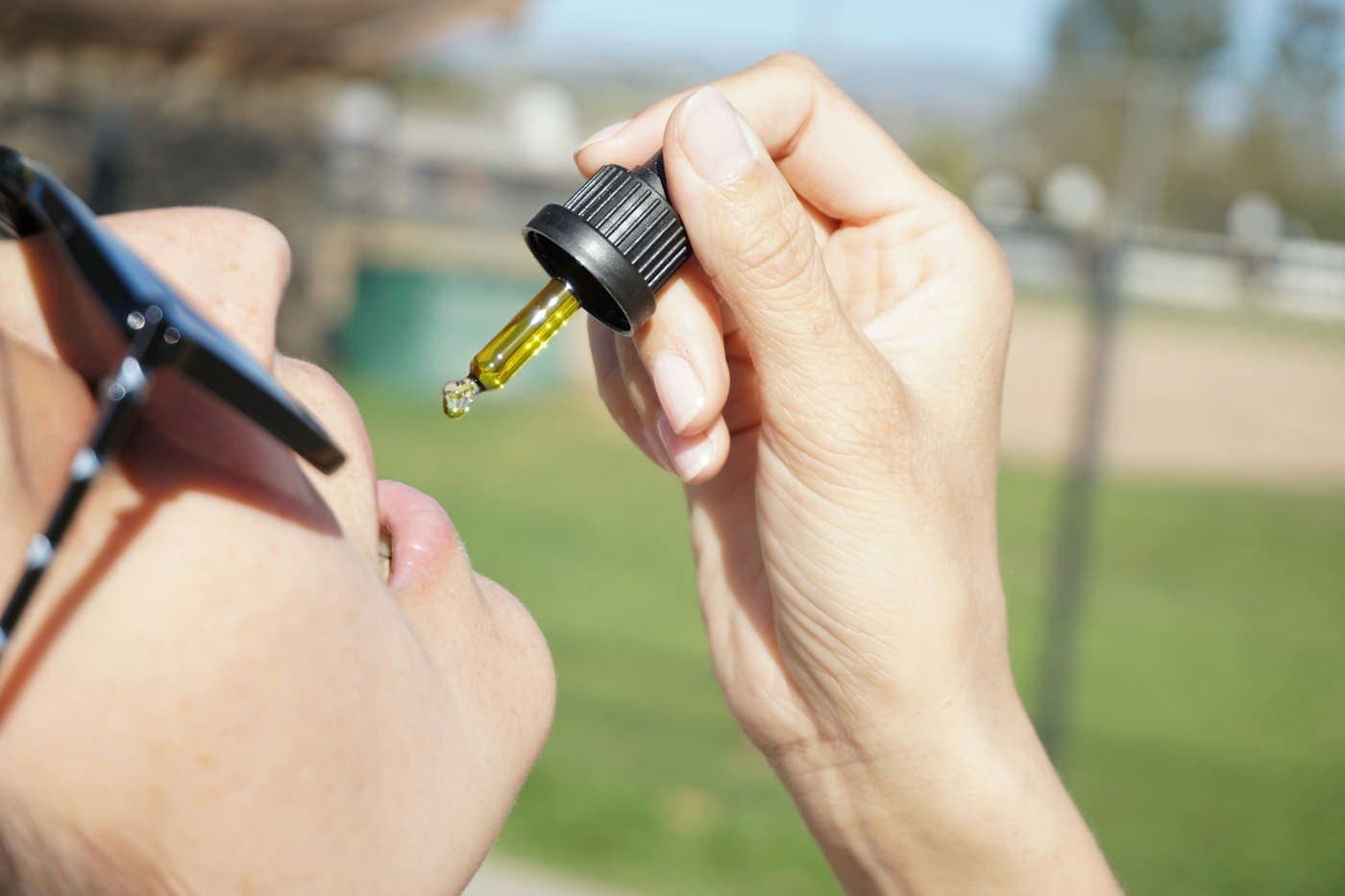 A person taking CBD oil from a dropper