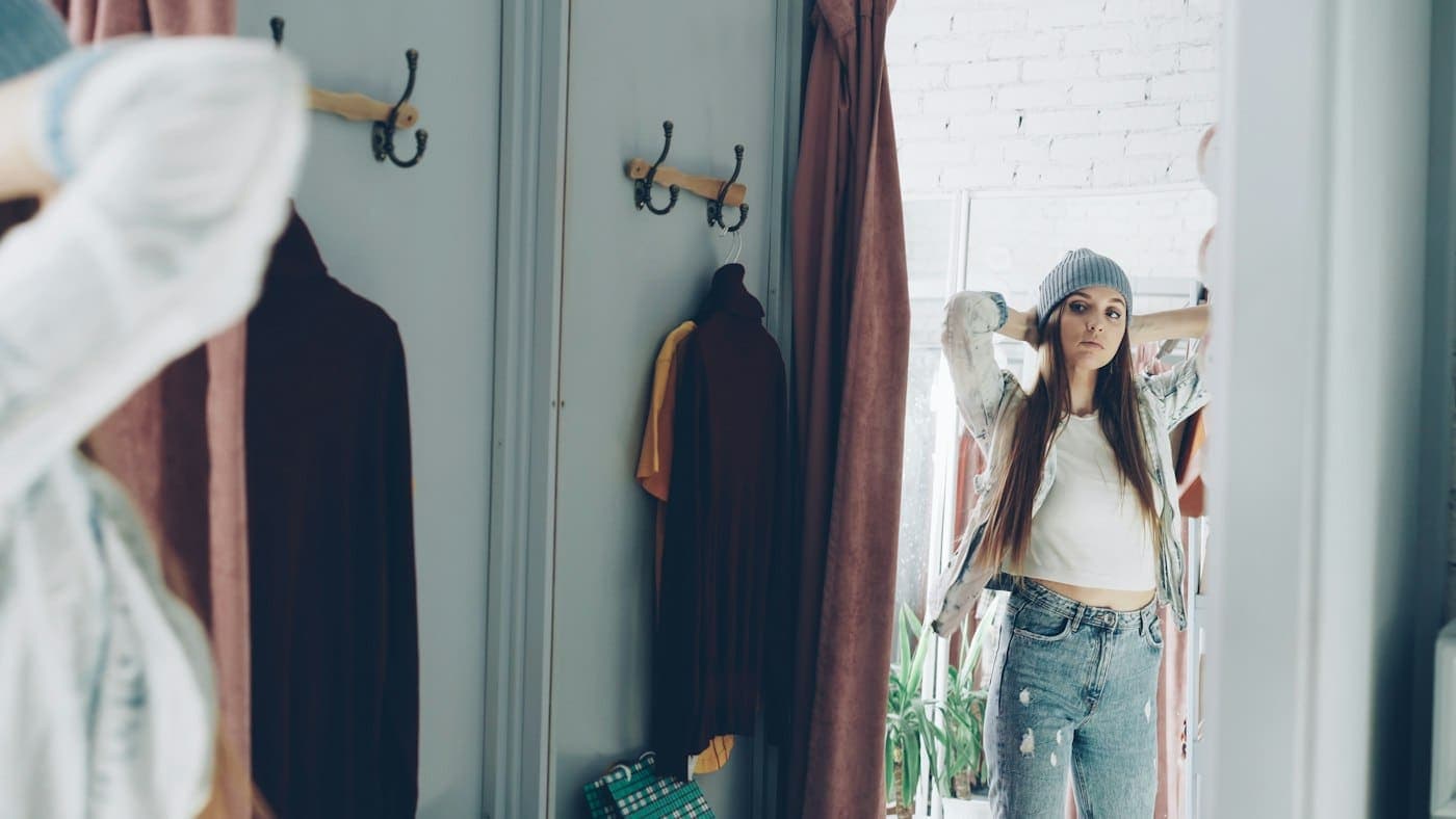 A shopper trying on clothes by a rail