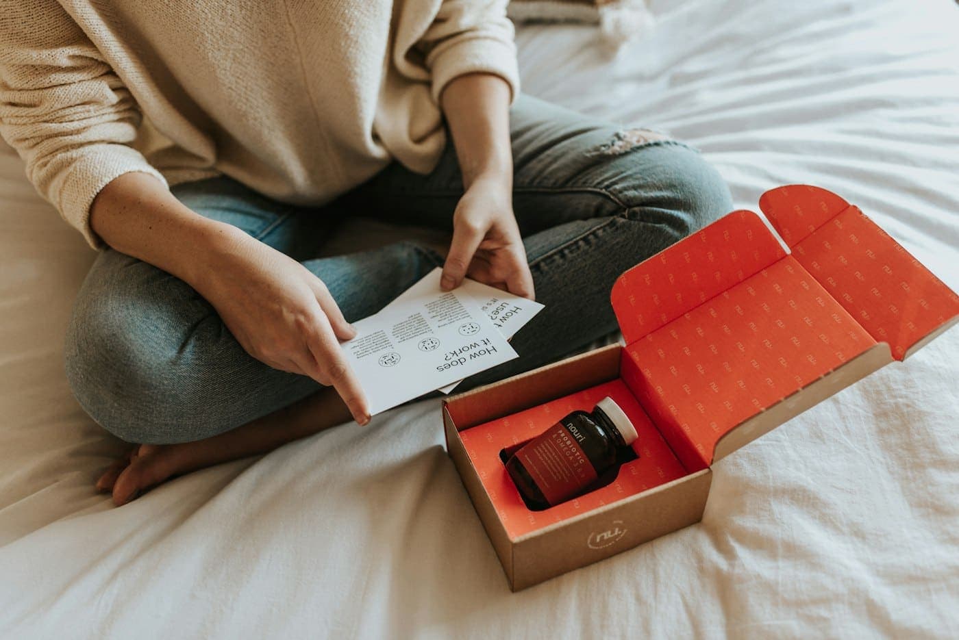 A customer unboxing a delivery on her bed